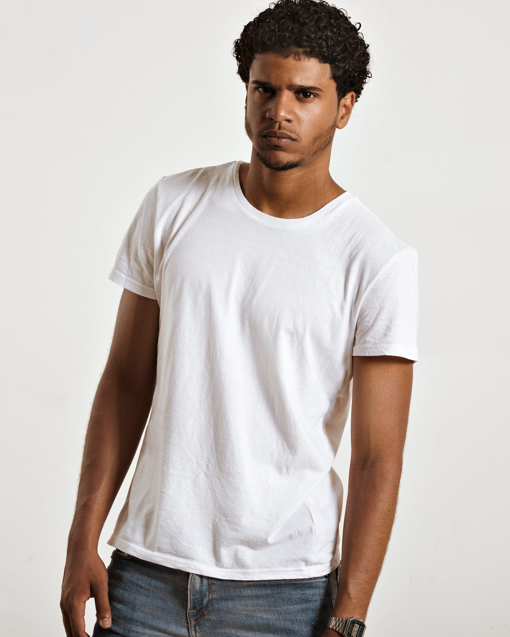 Man wearing a plain white t-shirt against a light gray background